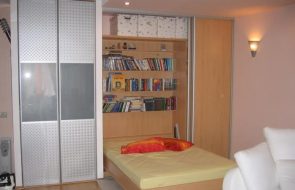 Letto in un armadio con nicchie per libri
