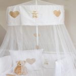 Un baldacchino per la culla può essere decorato con ricami o adesivi termoadesivi
