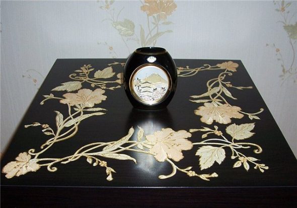 Il tavolo è decorato utilizzando la tecnica del decoupage con pittura di contorno