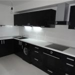 Piano di lavoro bianco e lavello nero in un interno di cucina moderna