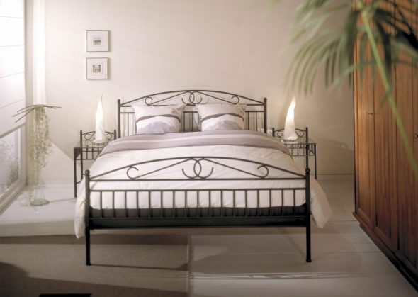 Inserisci letti in ferro battuto in un classico interno da camera da letto