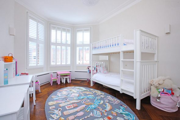 Letto a castello bianco, tavolino rosa vicino alla finestra