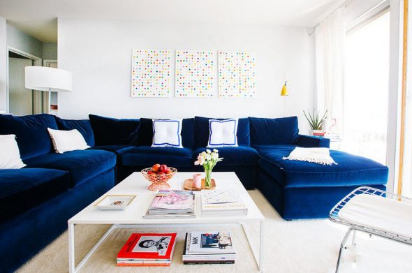 Grande divano blu all'interno di un luminoso soggiorno