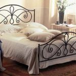 Un letto in ferro battuto aggiungerà romanticismo e colore a una camera da letto in stile provenzale