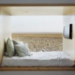 Un concetto originale di letto a podio inserito in una nicchia nel muro