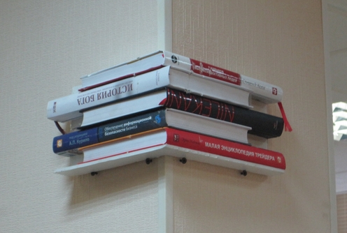 Angolo di un muro fatto di libri sotto la pietra naturale