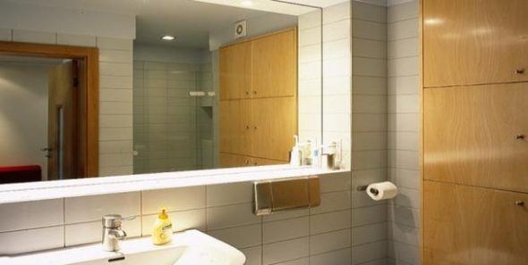 il modo per installare uno specchio nel bagno è incollarlo alle piastrelle