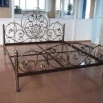 La testiera del letto in ferro battuto è accattivante