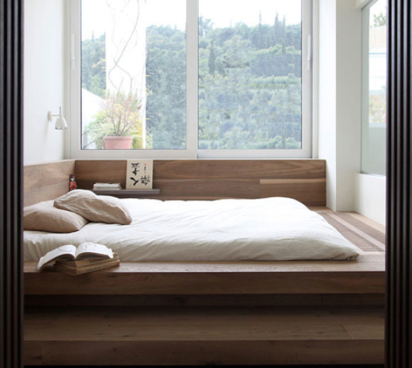 Letto a podio in legno vicino alla finestra
