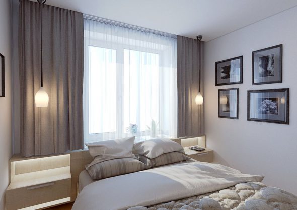 Interno di una piccola camera da letto con un letto posizionato al centro della stanza, con la testiera rivolta verso la finestra