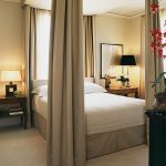 Letto insolito per adulti vicino alla finestra con baldacchino