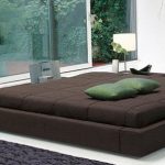 Ampia camera da letto con podio vicino a un'enorme finestra
