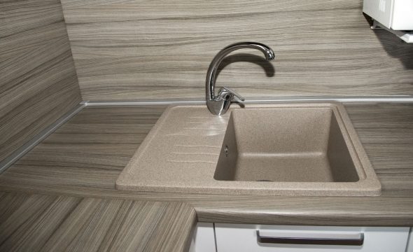 Piano di lavoro in pietra artificiale e zoccolo in alluminio nel colore della rubinetteria