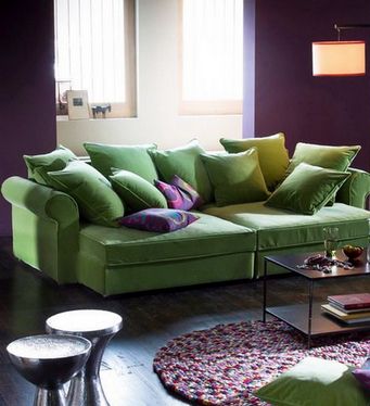 Un divano colorato viene introdotto in un interno di un colore diverso