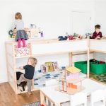 Due letti a soppalco con area giochi all'interno di una cameretta per tre bambini