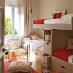 Un letto guardaroba per tre bambini e una zona soggiorno vicino alla finestra