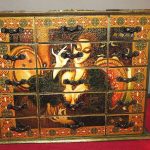 Decoupage di una cassettiera lucidata con vernice dorata