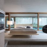 Un letto con effetto galleggiante al centro di una spaziosa camera da letto