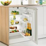 Piccola cucina con un piccolo frigorifero sotto il bancone