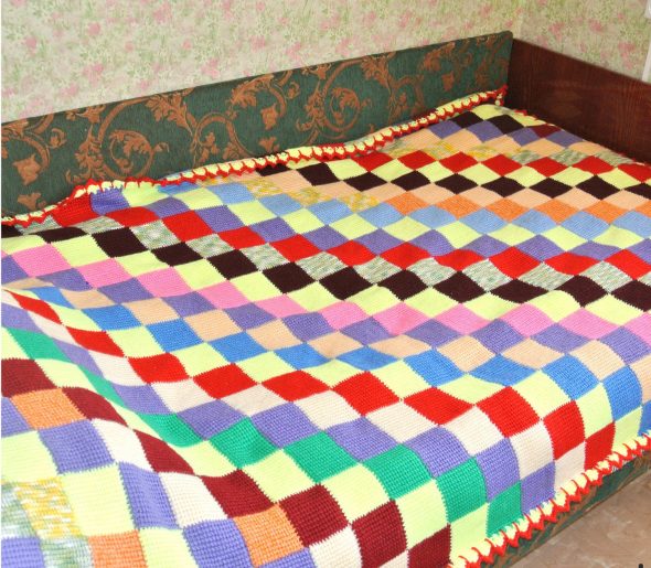 Copriletto luminoso realizzato con motivi quadrati colorati