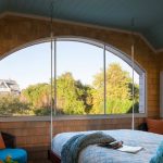 Letto sospeso vicino alla finestra ad arco