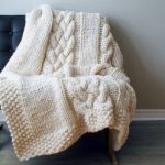 Graziosa coperta lavorata a maglia con trecce
