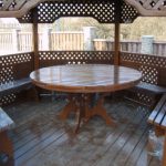 Un tavolo rotondo in legno è una delle soluzioni più popolari per un gazebo