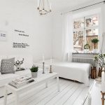 Soggiorno bianco con mobili bianchi lungo una parete
