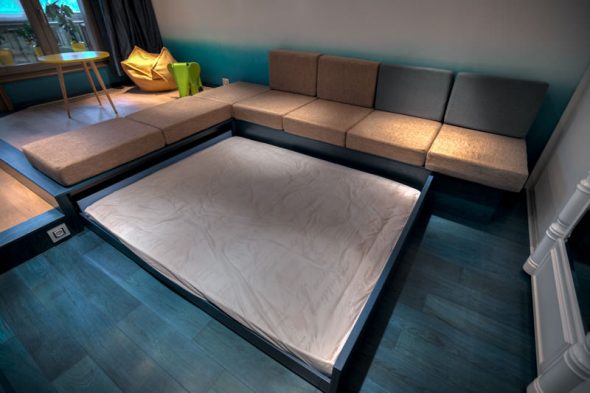 Un grande letto che esce da sotto il divano