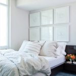 Interno di una piccola camera da letto con dipinti insoliti sopra il letto