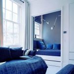 Letto in nicchia chiusa in una stanza nei toni del blu e del bianco