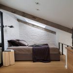 Camera da letto con pareti in mattoni al piano mansardato