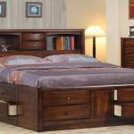 Letto in legno con testiera a forma di scaffale e cassetti incorporati