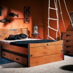 I cassetti in legno sotto il letto richiamano il comodino e la cassettiera