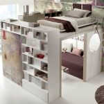 Design interessante con un letto sotto il soffitto e un armadio e un divano incorporati
