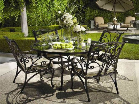 Un set di mobili da giardino in metallo con gambe e schienali traforati