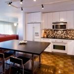 Cucina bianca fino al soffitto in un monolocale