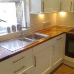 Cucina bianca con piano di lavoro in legno naturale