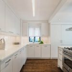 Ampia cucina bianca con mobili alti e unità alte