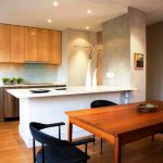 Cucina in legno con piano di lavoro in pietra e mobili alti fino al soffitto