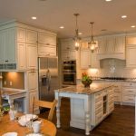 Cucina con isola e pensili alti fino al soffitto