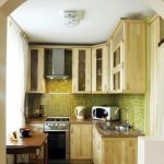 Piccola cucina in legno con mobili alti fino al soffitto