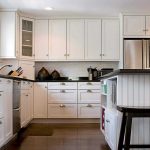Mobili alti fino al soffitto in una cucina contemporanea bianca