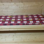 Letto singolo in legno in una stanza in legno con le tue mani