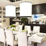 Un soffitto di piastrelle a specchio identiche aggiunge luce all'ampia sala da pranzo-soggiorno