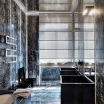 Bagno con finitura in marmo e soffitto a specchio