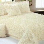 La coperta di pelliccia beige con i cuscini sembra chic