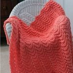 Bellissima coperta lavorata a maglia color corallo