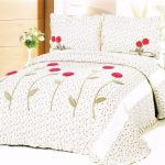 Copriletto con piccoli motivi floreali e grandi fiori decorativi