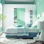 Armadio, letto e tavolo all'interno di una camera da letto in verde